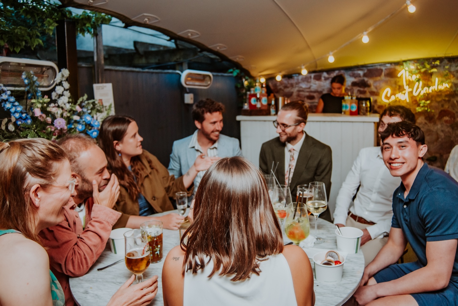 group of people drinking in the secret garden at the square club